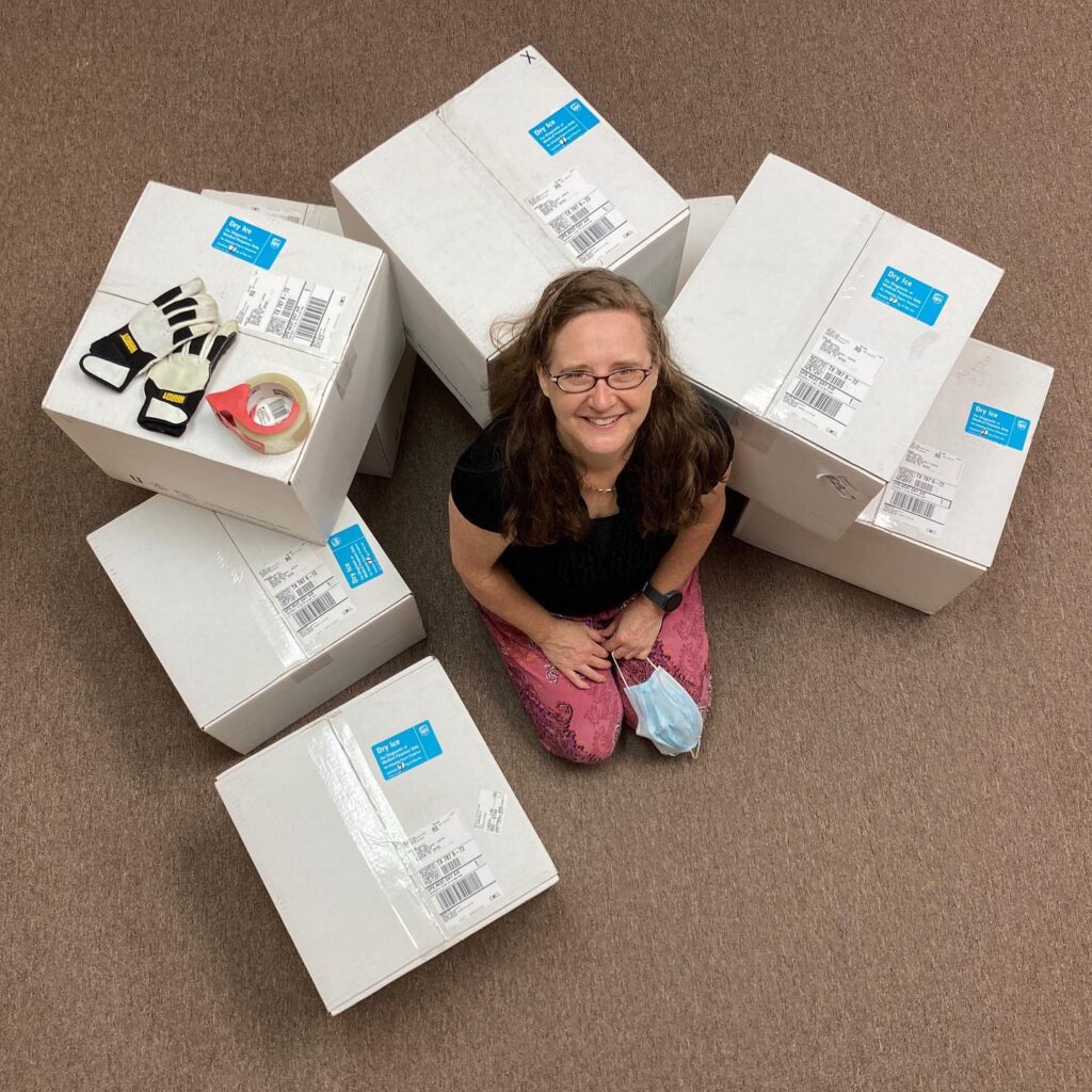 woman sitting amid boxes ready to be shipped.